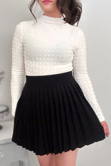 Close up of woman wearing a white top with a black-colored pleated mini skirt