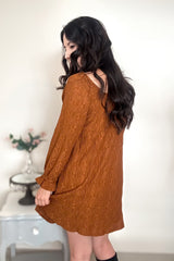 Side view of woman wearing a chestnut-colored mini dress