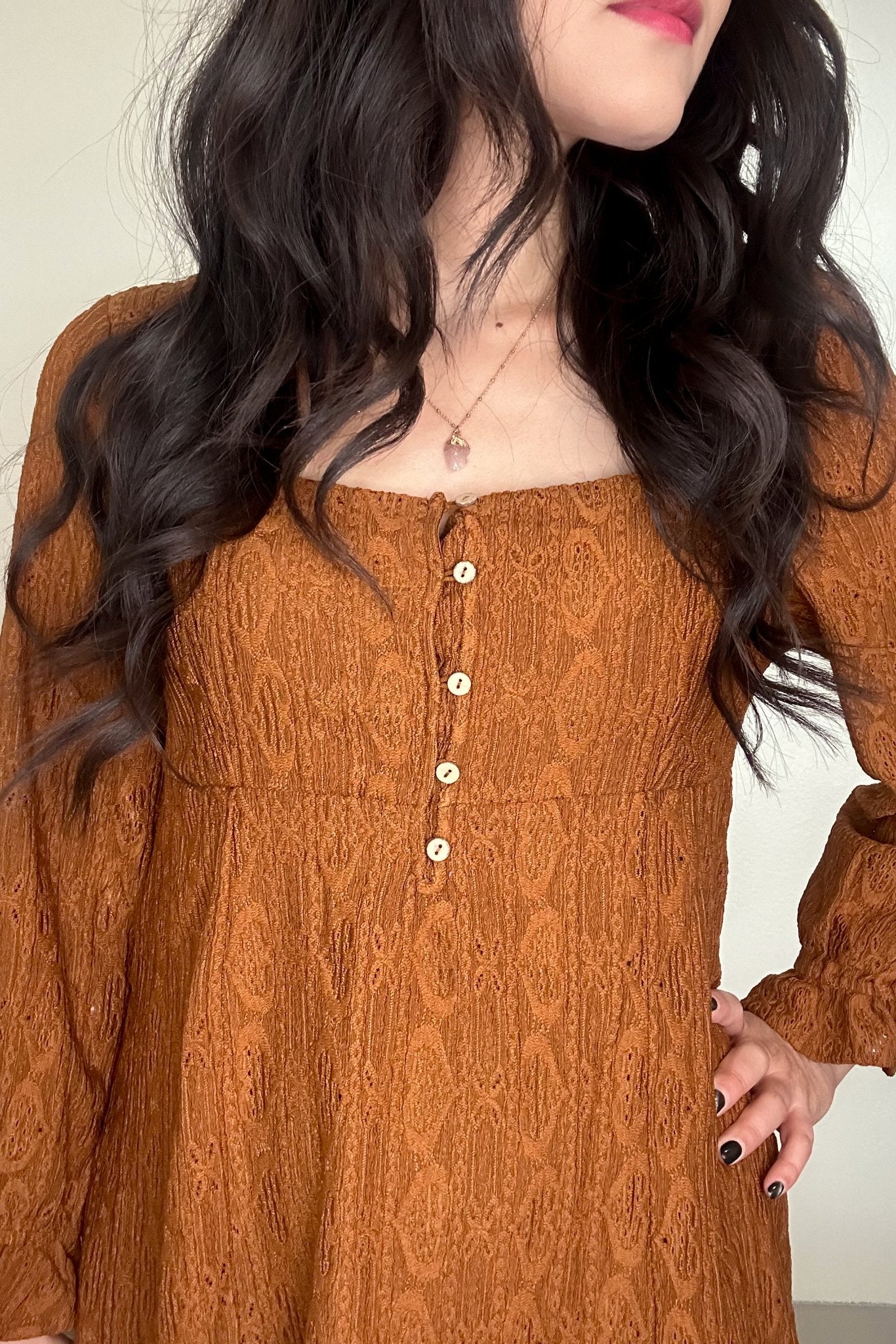 Close up of bodice of a woman wearing a chestnut-colored mini dress