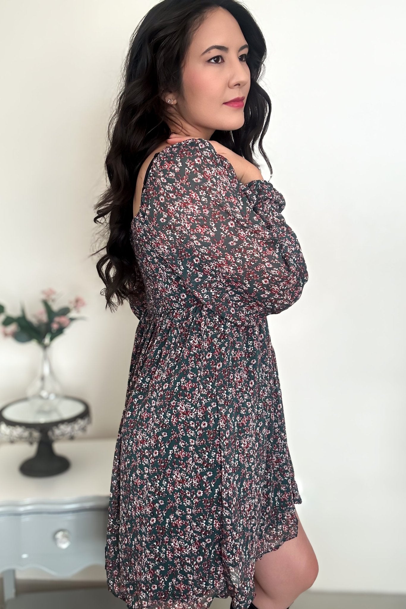 Side view of woman wearing a green floral mini dress