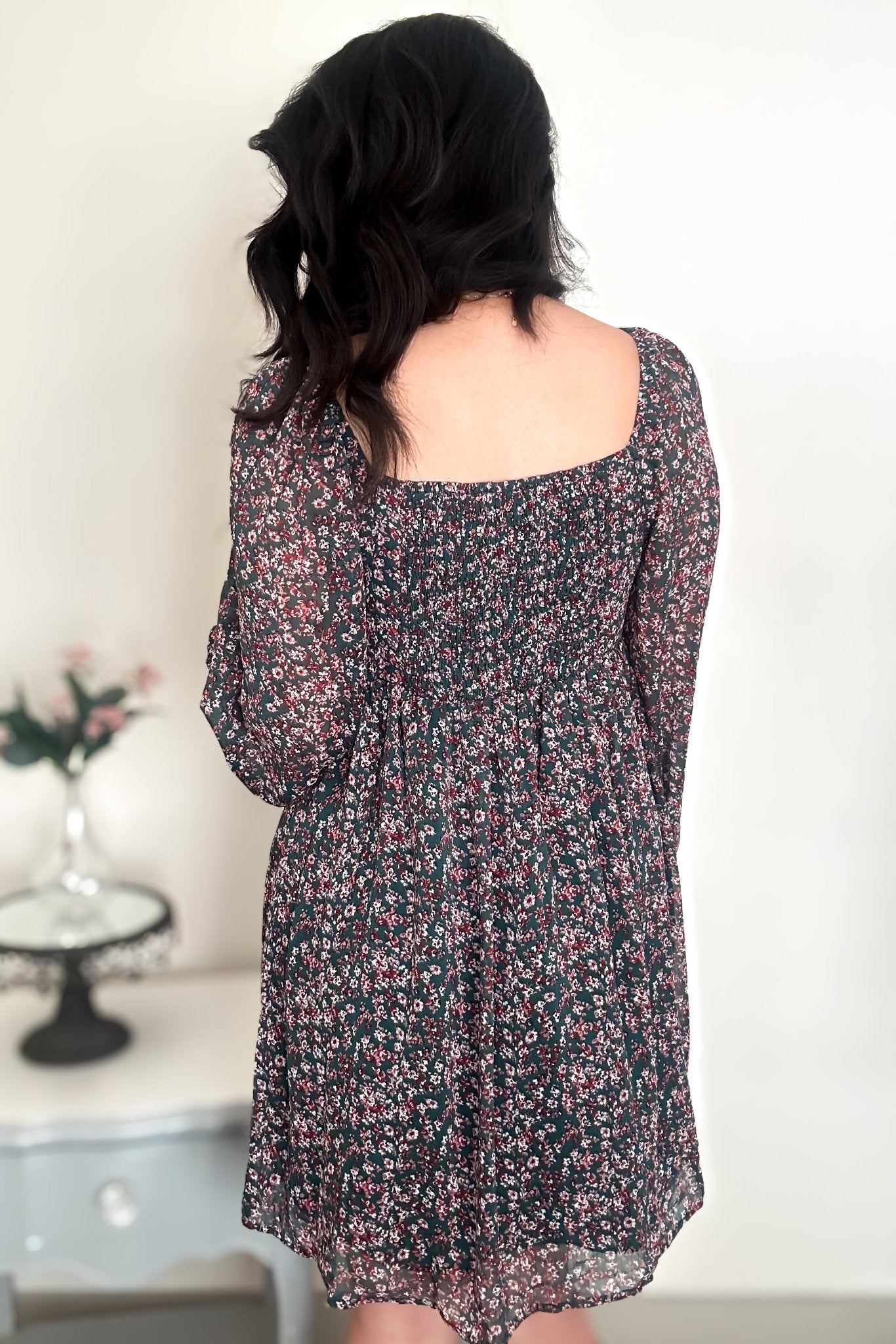 Back view of woman wearing a green floral mini dress