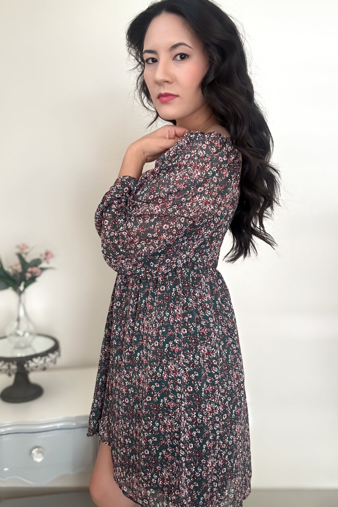 Side view of woman wearing a green floral mini dress